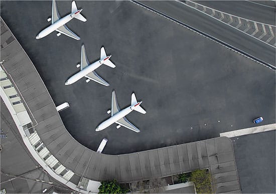 Photograph of planes docked at an airport from above